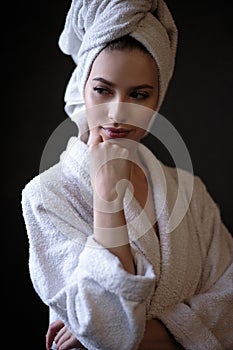 Young woman in a bathrobe and towel on her head, spa and care portrait, clean face