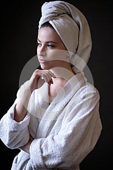 Young woman in a bathrobe and towel on her head, spa and care portrait, clean face