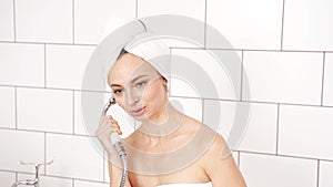 Young woman in bathroom talking by watering can. Luxury shower portrait