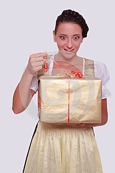 Young woman in Bavarian Dirndl grabs a gift from