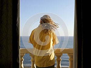 Young woman on beach hotel balcony. Costa del Sol