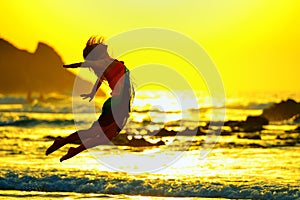 Young woman on the beach in summer sunset light