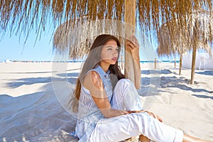 Young woman in a beach under parasol