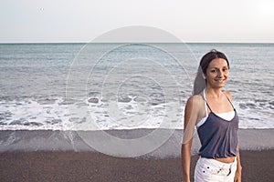 Young woman on the beach in very positive and happy attitude photo