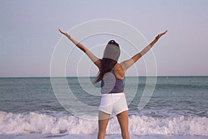 Young woman on the beach in very positive and happy attitude photo