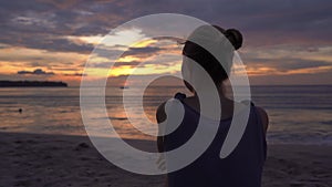 Young woman on a beach watching a fantastic sunset