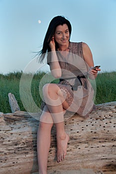 Young Woman Beachside Texting on Mobile Phone