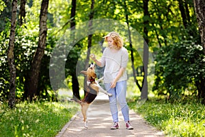 Young woman with Beagle dog in the summer park