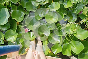 young woman with beautiful blue dreadlocks resting on yoga mat on lotus lake