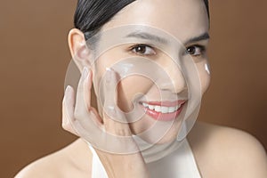 Young woman with beautiful face is holding cream , using cream of her face , beauty skin care concept