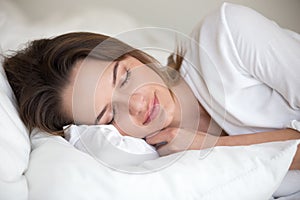 Young woman sleeping well lying asleep in comfortable cozy bed photo