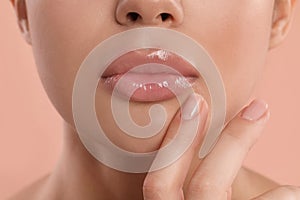 Young woman with beautiful full lips on peach background