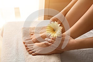 Young woman with beautiful pedicure and manicure after treatment in spa salon