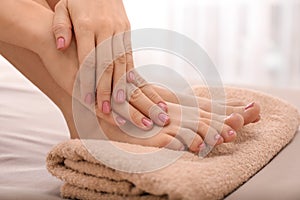 Young woman with beautiful pedicure and manicure after treatment in spa salon