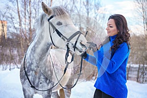 A young woman with a beautiful winter white horse