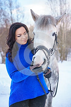 A young woman with a beautiful winter white horse