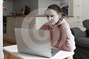 Young woman with beauty mask at home. Snackable wellness concept. Self care for home office . Quick face mask for home