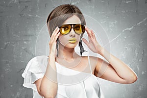 Young woman beauty portrait with yellow sun glasses.Hand touchi