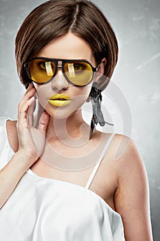Young woman beauty portrait with yellow sun glasses.Hand touchi