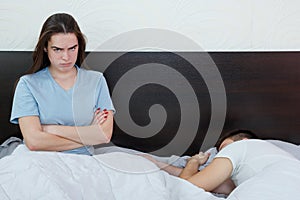 Young woman in bed with sad and disappointed expression on her f