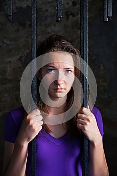 Young woman behind the bars