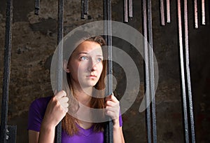 Young woman behind the bars