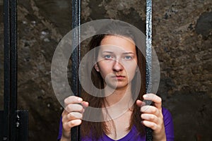 Young woman behind the bars