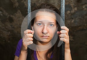 Young woman behind the bars