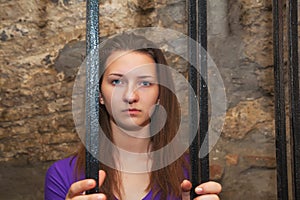 Young woman behind the bars