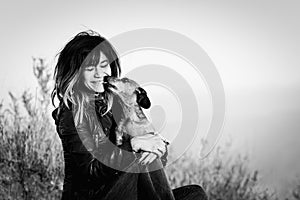 Young woman being licked by dachshund