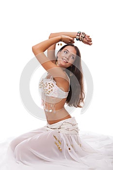 Young woman belly dancer in white costume