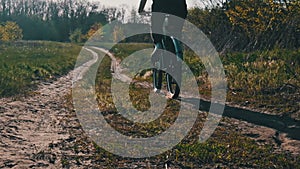 Young Woman on Bicycle Rides Along Green Forest Path in Summer Day, Slow Motion