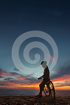 Young woman with bicycle at the sea beach