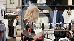 Young woman during big shopping in the clothes store