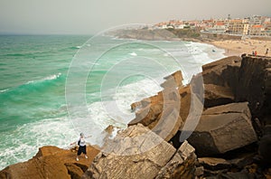 Young woman on a big stone of Praia das Macas. Sintra, Portugal photo