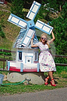 Young woman and a big toy flouring-mill