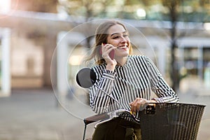 Young woman On Bike Using Mobile Phone