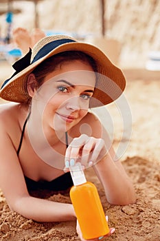 Young Woman in Bikini  Holding  Bottles of Sun Cream in Her Hands. Skincare.