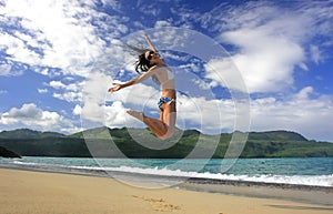 Young woman in bikini jumping at Rincon beach, Samana peninsula photo