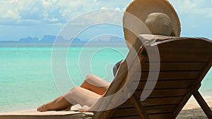 Young woman in bikini lounging on a beach chair, enjoying a luxurious tropical resort