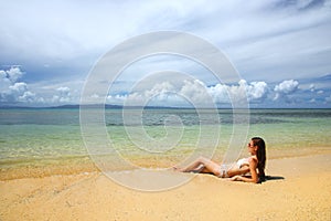 Young woman in bikini lying on the beach on Taveuni Island, Fiji