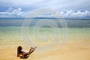 Young woman in bikini lying on the beach on Taveuni Island, Fiji