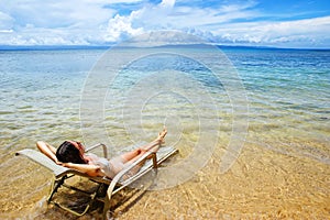 Young woman in bikini lying in a sun chair on Taveuni Island, Fiji