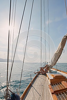 Young woman in bikini relaxing sunbathing on a boat. Woman on a boat sunbathing enjoying the sunshine. Young content