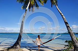 Young woman in bikini sitting in a hammock