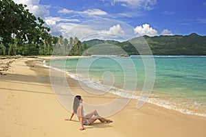 Young woman in bikini sitting at Rincon beach, Samana peninsula photo