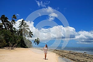 Young woman in bikini standing on the beach of Makaha`a island n