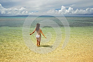 Young woman in bikini standing in clear water on Taveuni Island, Fiji