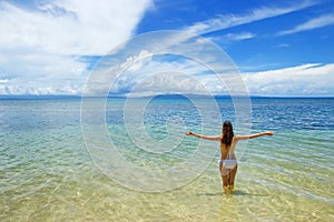 Young woman in bikini standing in clear water on Taveuni Island, Fiji