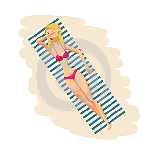 Young woman in bikini sunbathing lying on the beach